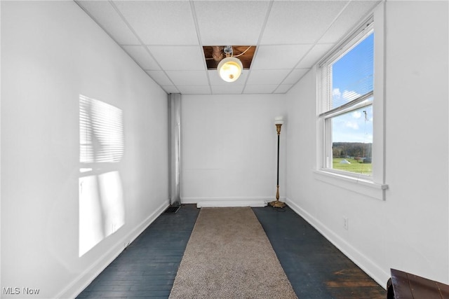5706 Kemary Ave SW, Navarre, OH 44662 - unfurnished room featuring dark wood-style floors, a drop ceiling, and baseboards