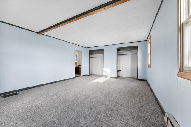 5706 Kemary Ave SW, Navarre, OH 44662 - unfurnished bedroom featuring baseboards, carpet floors, visible vents, multiple closets, and a baseboard radiator