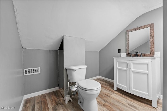 5706 Kemary Ave SW, Navarre, OH 44662 - bathroom with vaulted ceiling, visible vents, toilet, wood finished floors, and baseboards
