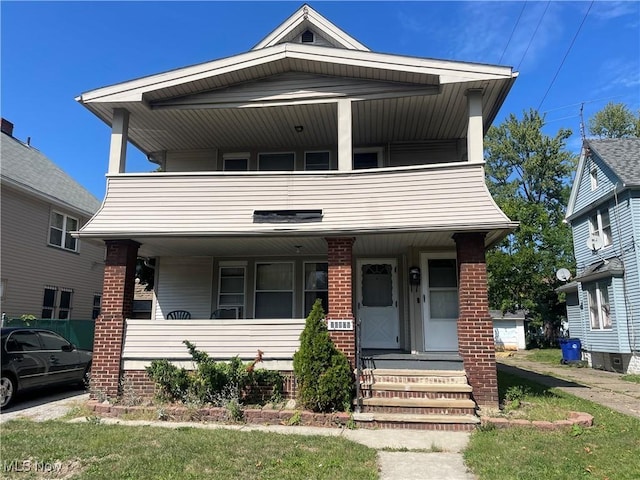 view of front facade with brick siding, a porch, and a balcony