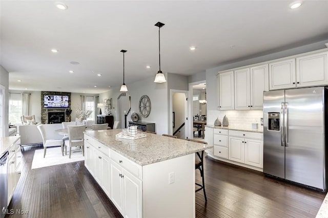 kitchen featuring white cabinetry, a kitchen island, stainless steel fridge, and recessed lighting