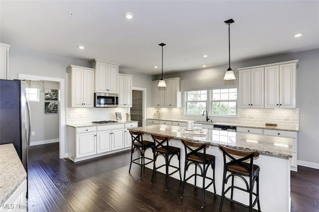 kitchen featuring baseboards, white cabinetry, and stainless steel appliances