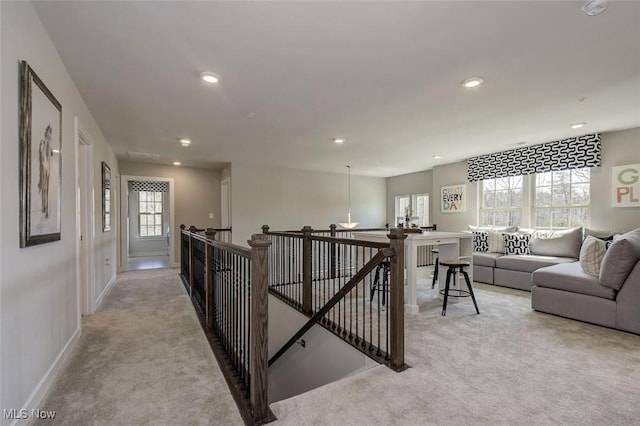 corridor with baseboards, recessed lighting, an upstairs landing, plenty of natural light, and light colored carpet