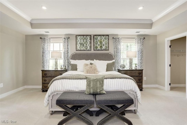 bedroom featuring crown molding, a tray ceiling, multiple windows, and light carpet