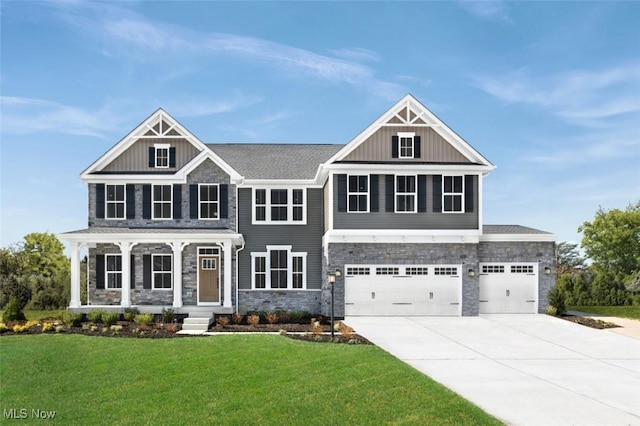 view of front facade featuring board and batten siding, driveway, a front yard, and stone siding