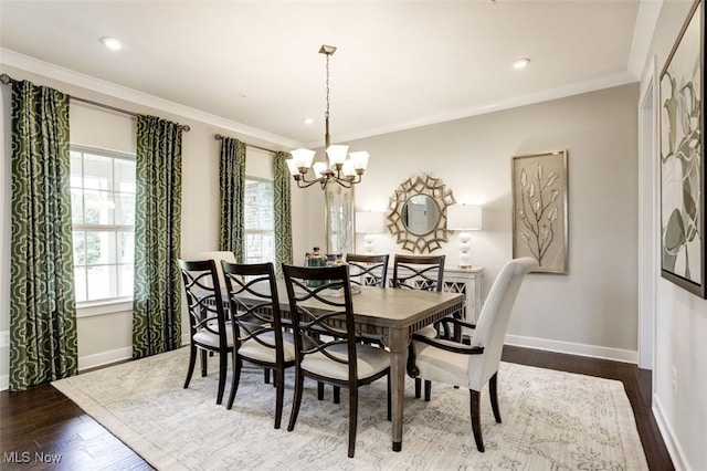 dining space featuring dark wood-type flooring, baseboards, a notable chandelier, and crown molding