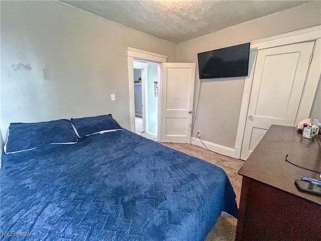 bedroom with a textured ceiling and baseboards