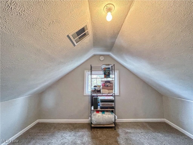bonus room featuring a textured ceiling, carpet flooring, vaulted ceiling, and visible vents