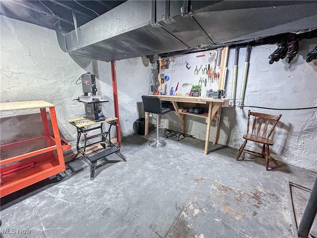 unfinished basement featuring a workshop area