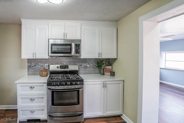 541 Canova Dr, Akron, OH 44319 - kitchen featuring light countertops, white cabinets, dark wood-type flooring, decorative backsplash, and stainless steel appliances