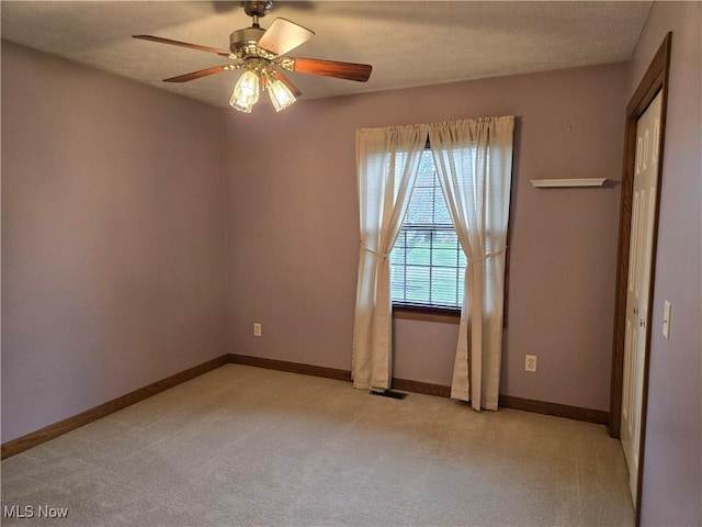 unfurnished room with light carpet, baseboards, and a ceiling fan