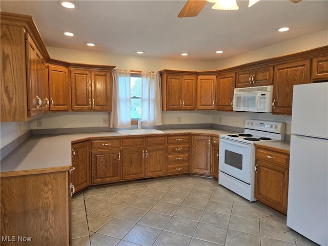 kitchen with white appliances, brown cabinets, and a sink
