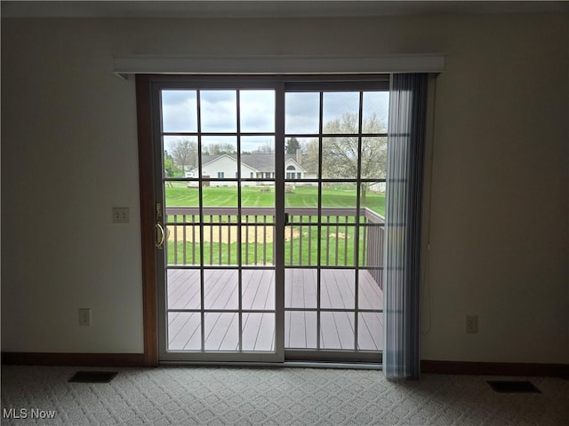 doorway to outside with visible vents, baseboards, and carpet flooring