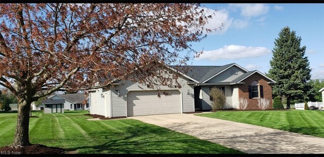 view of front facade featuring a front yard, an attached garage, brick siding, and driveway