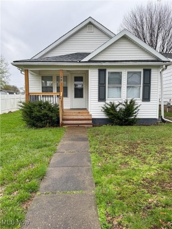 1313 12th St, Vienna, WV 26105 - bungalow-style house featuring a porch, fence, and a front lawn