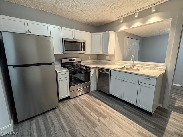 1313 12th St, Vienna, WV 26105 - kitchen with track lighting, appliances with stainless steel finishes, a sink, and light countertops