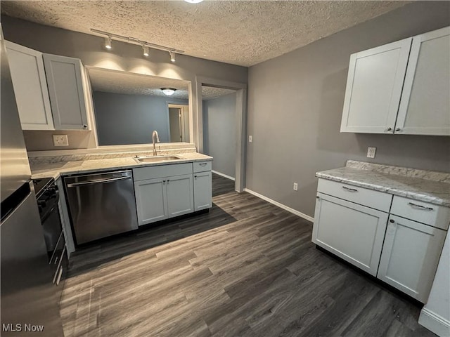 1313 12th St, Vienna, WV 26105 - kitchen with track lighting, light countertops, dark wood-type flooring, dishwasher, and a sink
