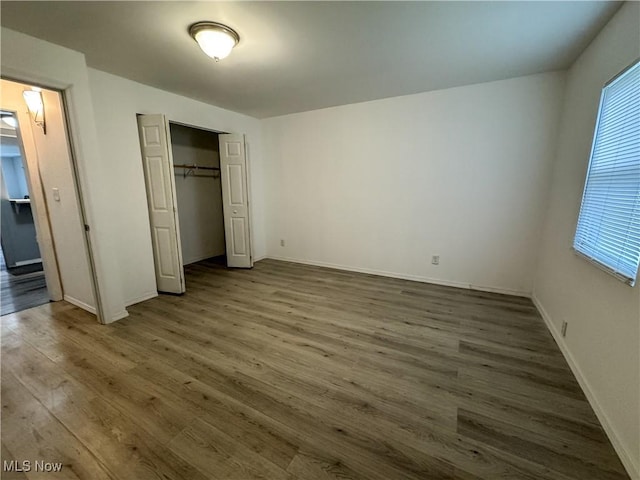1313 12th St, Vienna, WV 26105 - unfurnished bedroom with a closet, baseboards, multiple windows, and wood finished floors