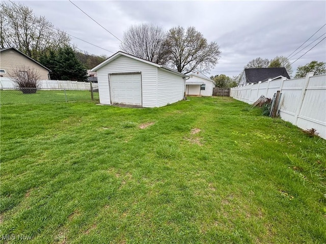 1313 12th St, Vienna, WV 26105 - view of yard featuring a fenced backyard, driveway, an outdoor structure, and a garage