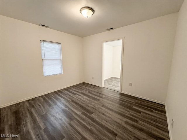 1313 12th St, Vienna, WV 26105 - empty room featuring dark wood-type flooring, visible vents, and baseboards
