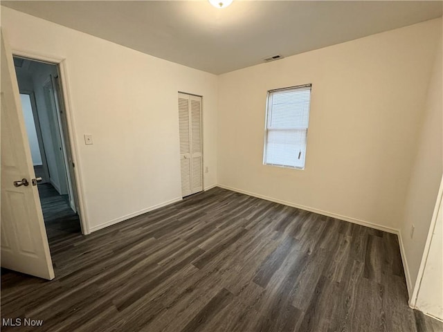 1313 12th St, Vienna, WV 26105 - unfurnished bedroom featuring visible vents, a closet, baseboards, and dark wood-style floors