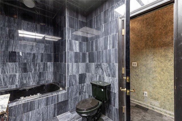 full bath featuring tile walls, toilet, and a relaxing tiled tub