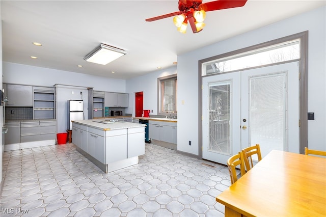 kitchen with light floors, french doors, light countertops, ceiling fan, and dishwashing machine