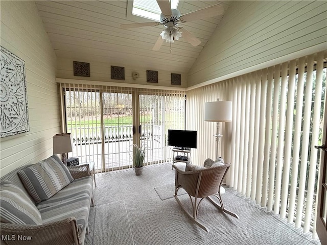 living area featuring wood walls, carpet, ceiling fan, and lofted ceiling