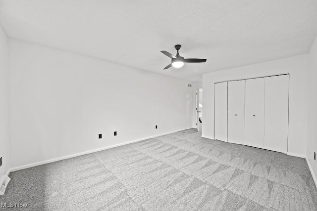 unfurnished bedroom with a closet, ceiling fan, baseboards, and carpet