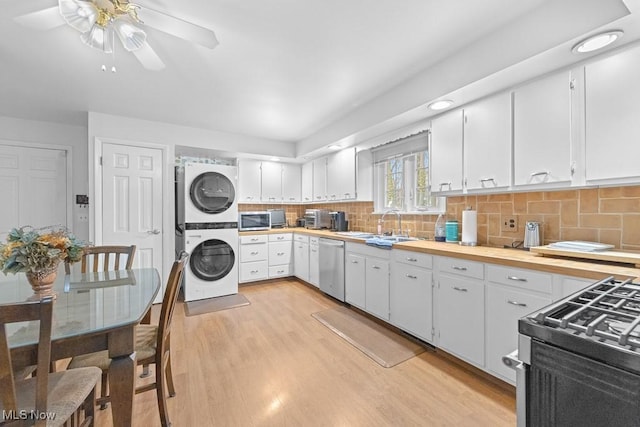 841 W Milton St, Alliance, OH 44601 - kitchen featuring a sink, ceiling fan, light wood-type flooring, appliances with stainless steel finishes, and stacked washer / drying machine