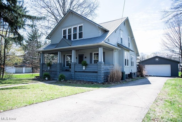 144 S Walnut St, Gnadenhutten, OH 44629 - bungalow-style house with covered porch, a garage, an outbuilding, metal roof, and a front lawn