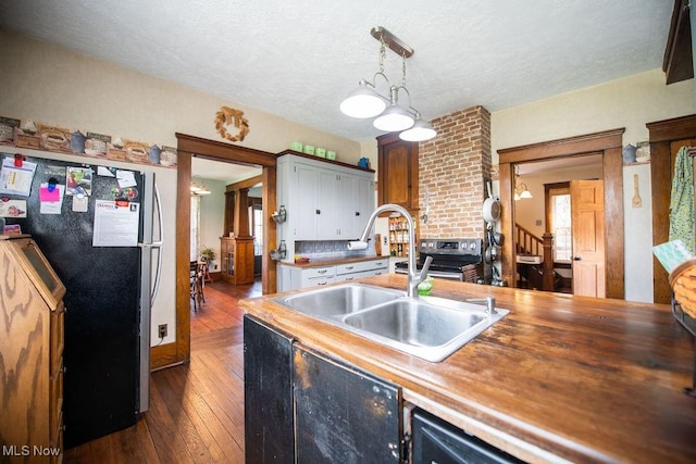 144 S Walnut St, Gnadenhutten, OH 44629 - kitchen featuring a sink, a textured ceiling, pendant lighting, dark wood-style flooring, and appliances with stainless steel finishes