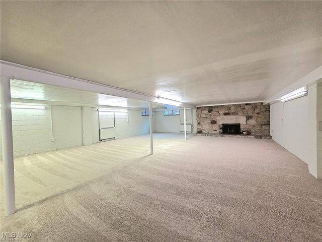 basement with a fireplace and carpet flooring