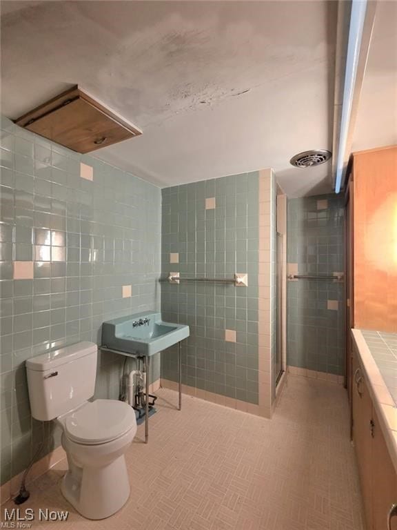bathroom featuring an enclosed shower, visible vents, tile walls, and toilet