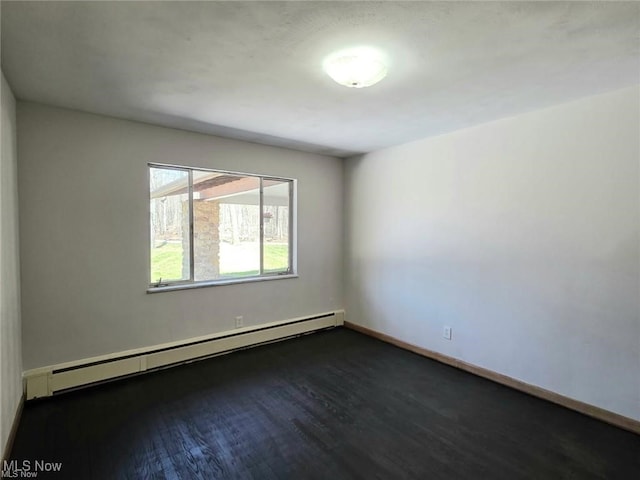 empty room with a baseboard radiator, baseboards, and dark wood finished floors