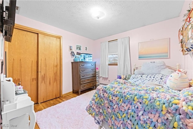 4000 S Mahoning Ave, Alliance, OH 44601 - bedroom with a closet, light wood-type flooring, and a textured ceiling