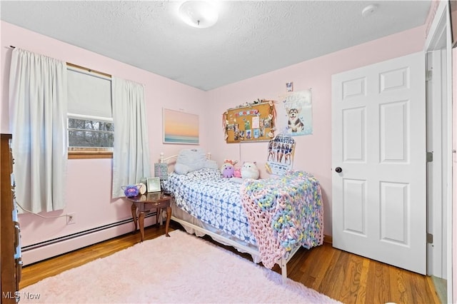 4000 S Mahoning Ave, Alliance, OH 44601 - bedroom featuring baseboard heating, a textured ceiling, and wood finished floors