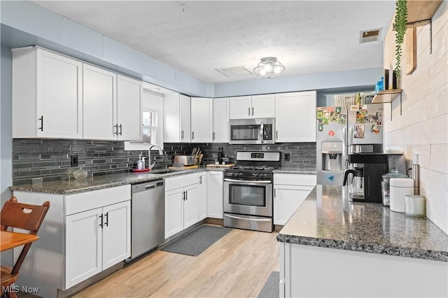 4000 S Mahoning Ave, Alliance, OH 44601 - kitchen featuring white cabinets, visible vents, light wood-type flooring, and appliances with stainless steel finishes