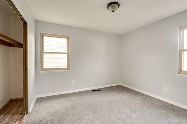 unfurnished bedroom with carpet flooring, visible vents, and baseboards