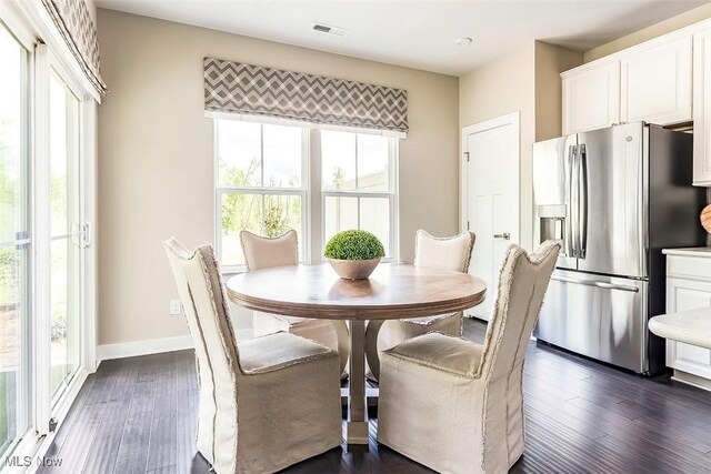 dining room with visible vents, baseboards, and dark wood finished floors