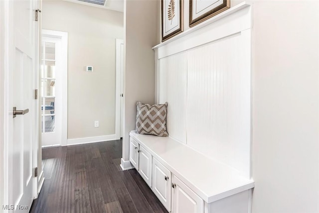 mudroom with dark wood-style flooring and baseboards