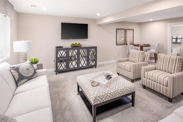 living area with baseboards, recessed lighting, and light carpet