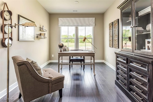 home office with dark wood-type flooring and baseboards