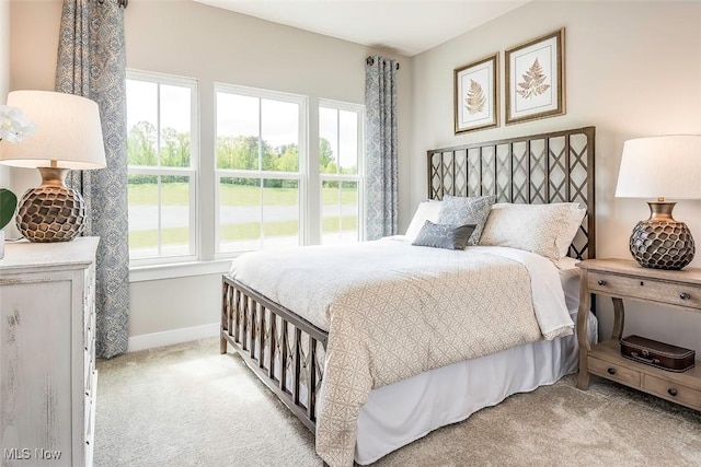 carpeted bedroom featuring baseboards and multiple windows