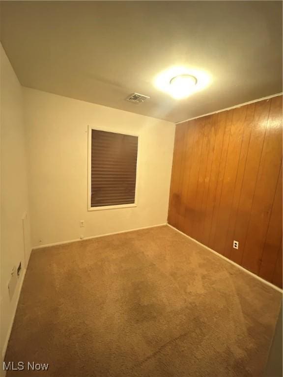 2424 Mccartney Rd, Youngstown, OH 44505 - spare room with wood walls, carpet, and visible vents