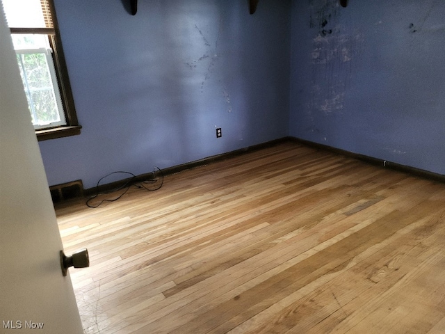 empty room featuring baseboards and wood finished floors