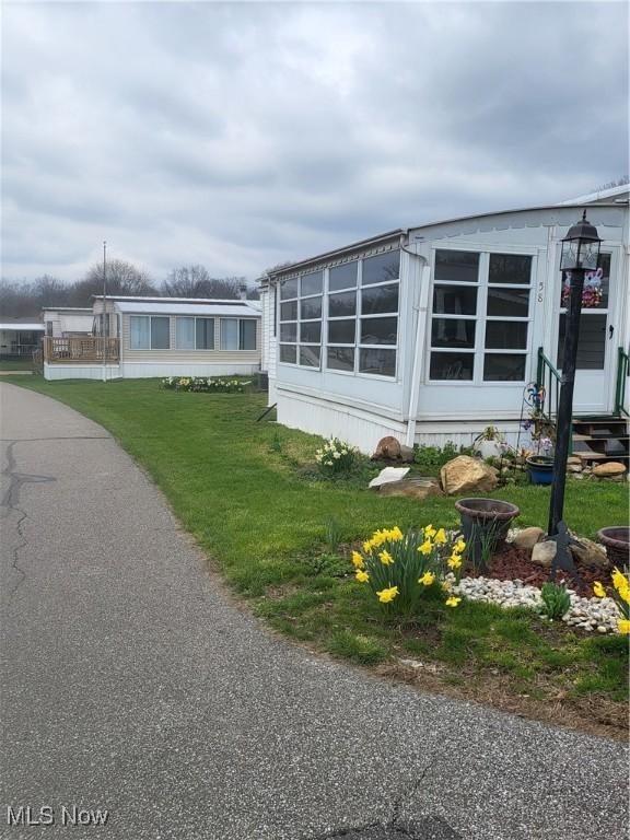 58 Wilpark Dr, Akron, OH 44312 - view of home's exterior featuring entry steps and a lawn