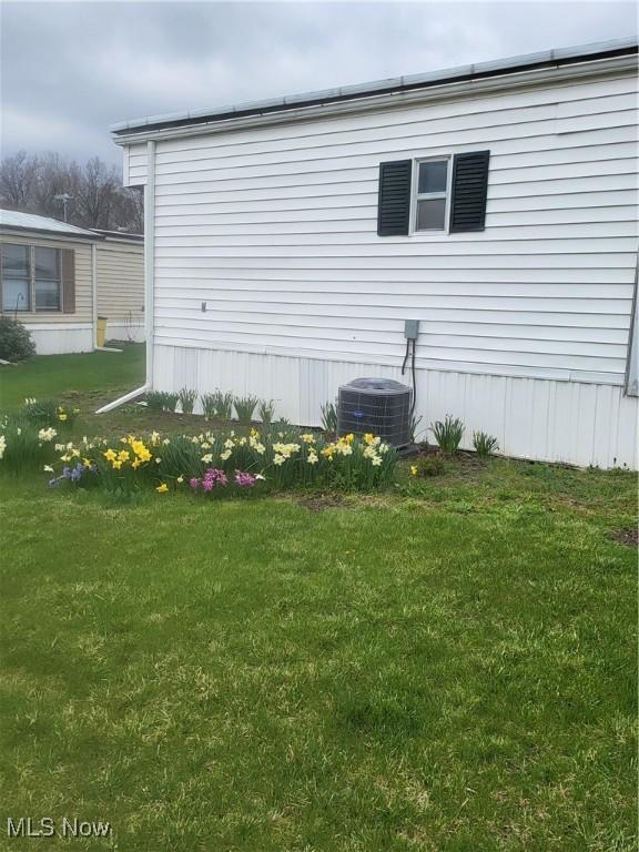 58 Wilpark Dr, Akron, OH 44312 - view of home's exterior with central air condition unit and a lawn
