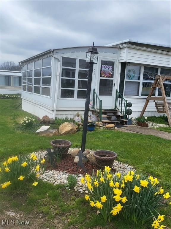 58 Wilpark Dr, Akron, OH 44312 - manufactured / mobile home with a front yard and entry steps