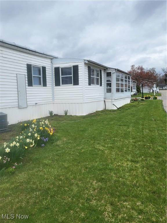 58 Wilpark Dr, Akron, OH 44312 - view of home's exterior featuring central AC unit and a lawn